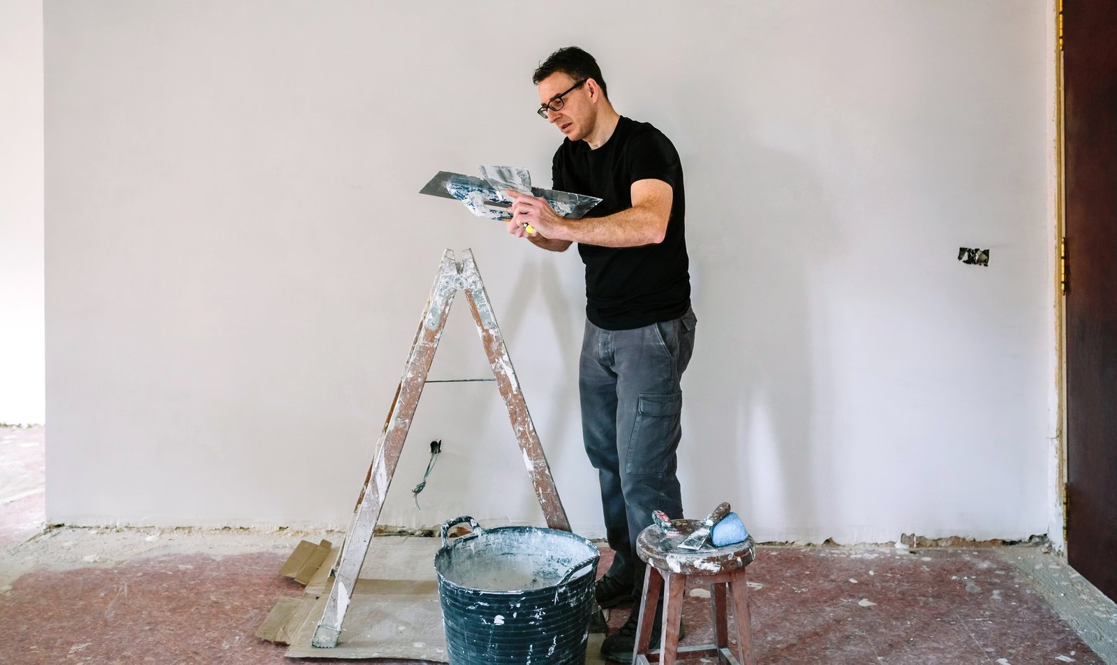 Builder working picking plaster with spatula