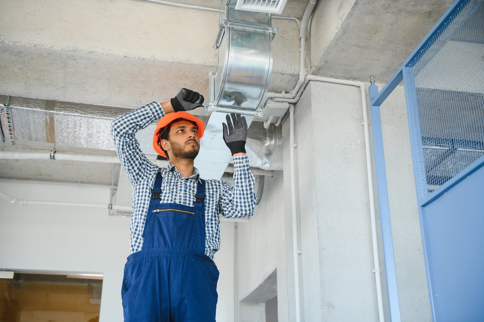 indian worker install ducted pipe system for ventilation and air conditioning in house