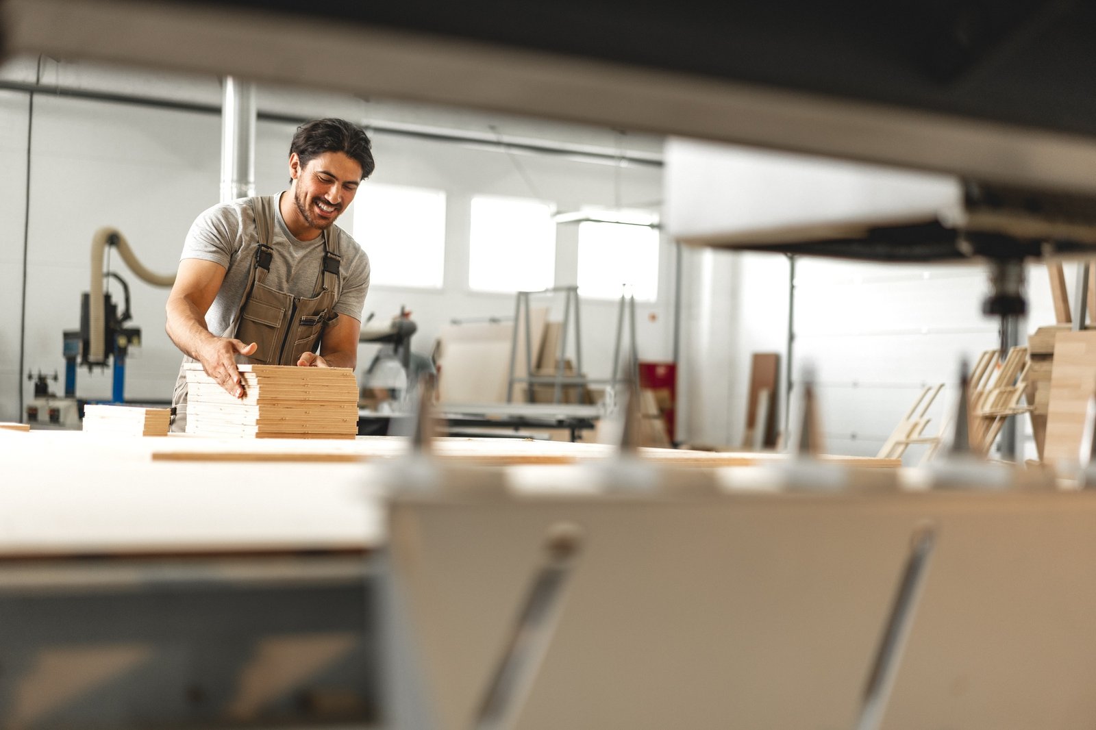 Young man doing woodwork in carpentry factory